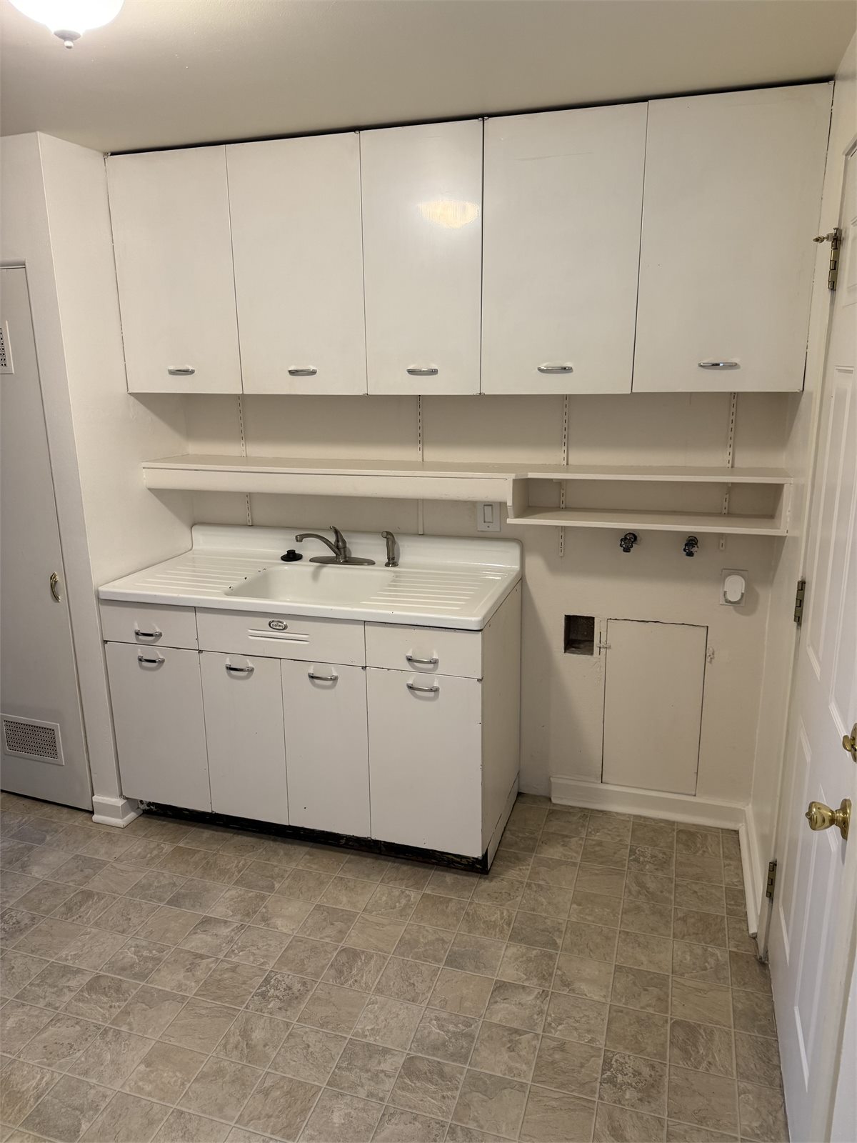 Kitchen sink, storage cabinets, and washer hookup